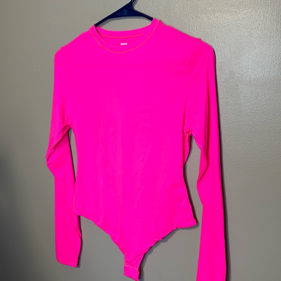 Tops - Fits everybody long sleeve crewneck bodysuit by skins neon pink is the color